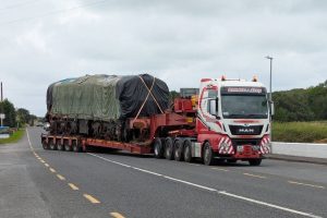Wrapped and ready to go, A class loco A3R sits on the RSS low loader as it slowly draws out of the compound at Moyasta.